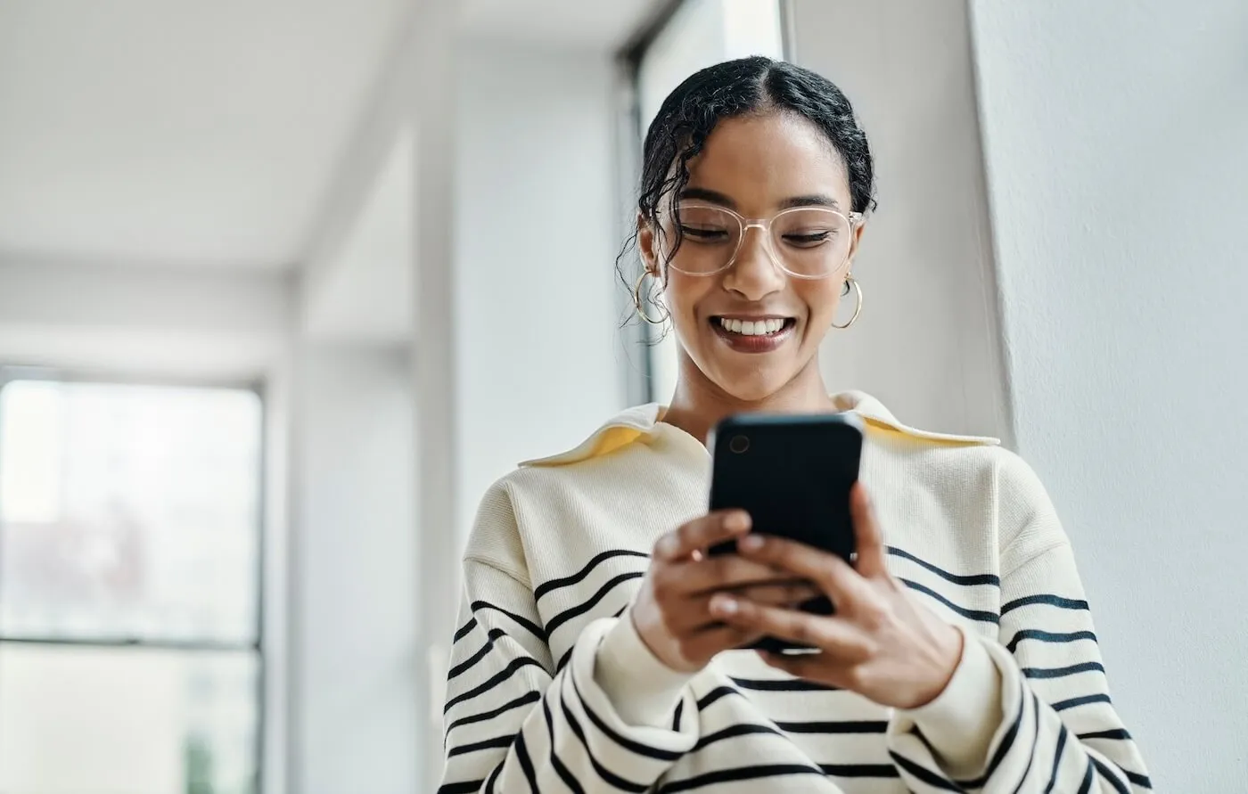 Smiling young woman checking her smartphone
