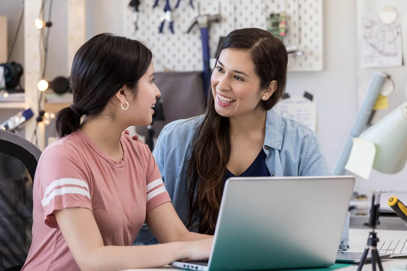 Two smiling women using a laptop at home