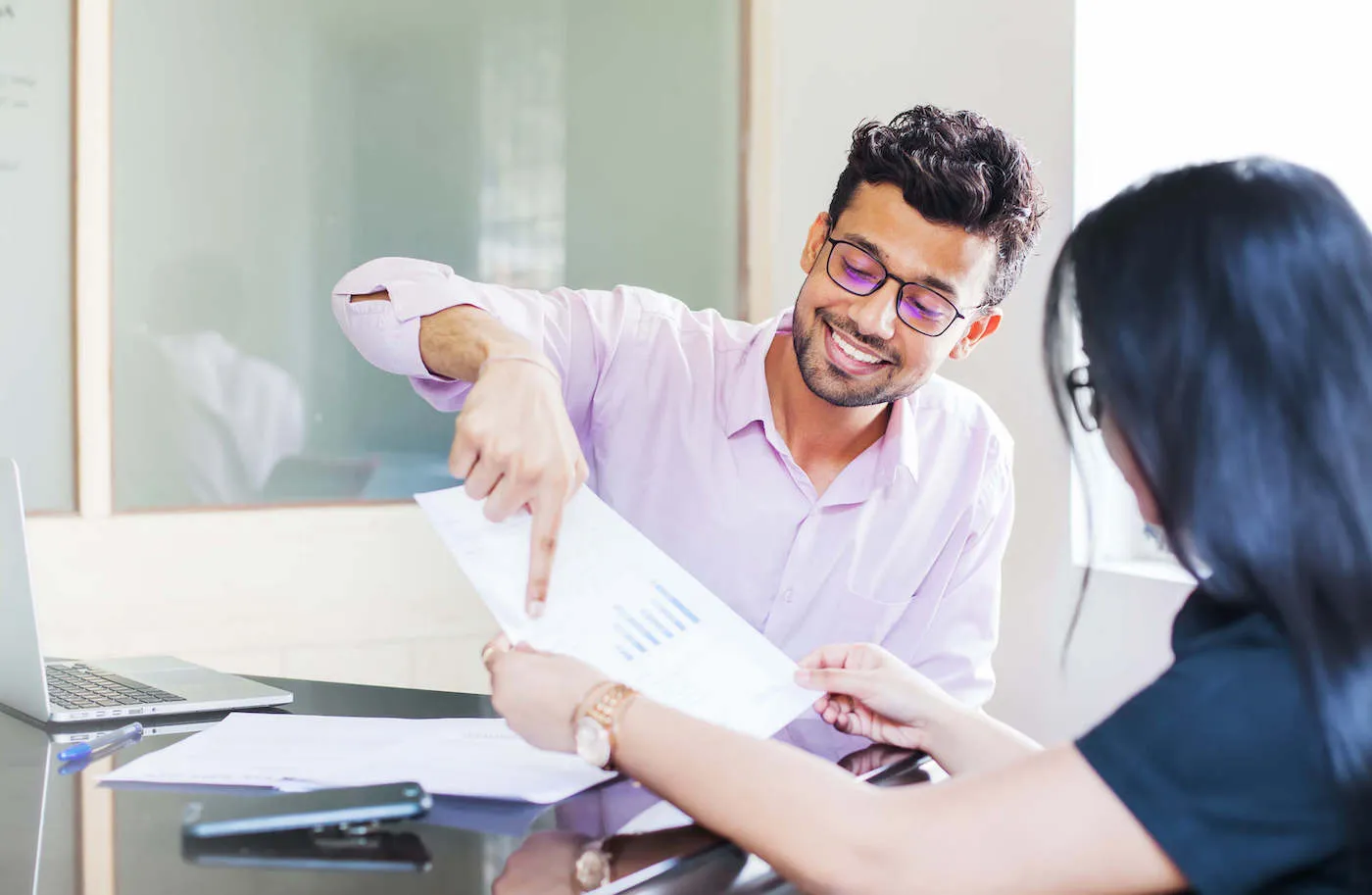 Smiling man explaining mutual funds to a woman in the office