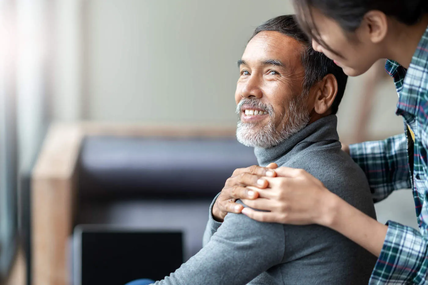 Mature man smiling at woman with her hand on his shoulder
