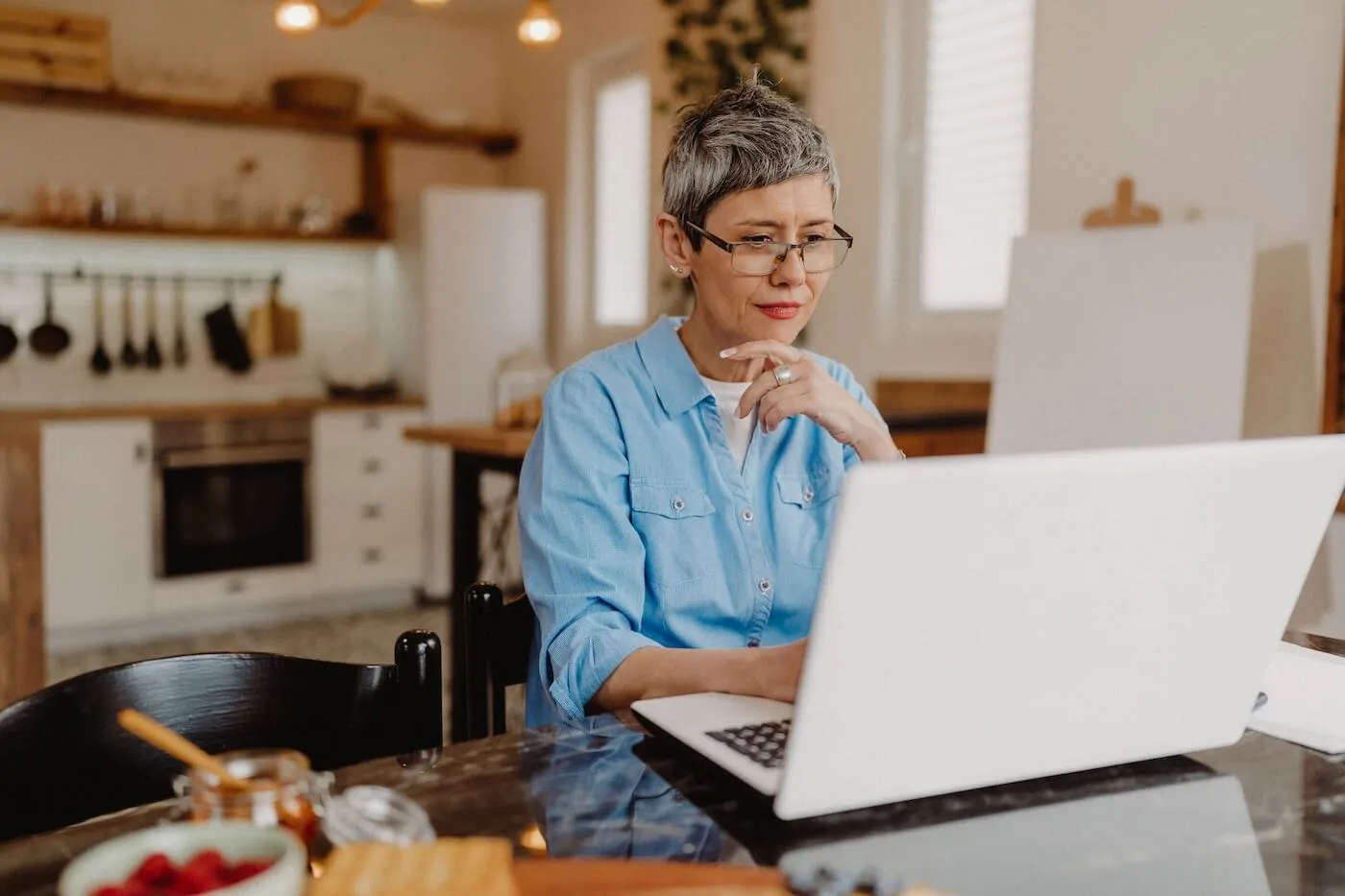 Mature woman using her laptop in the kitchen