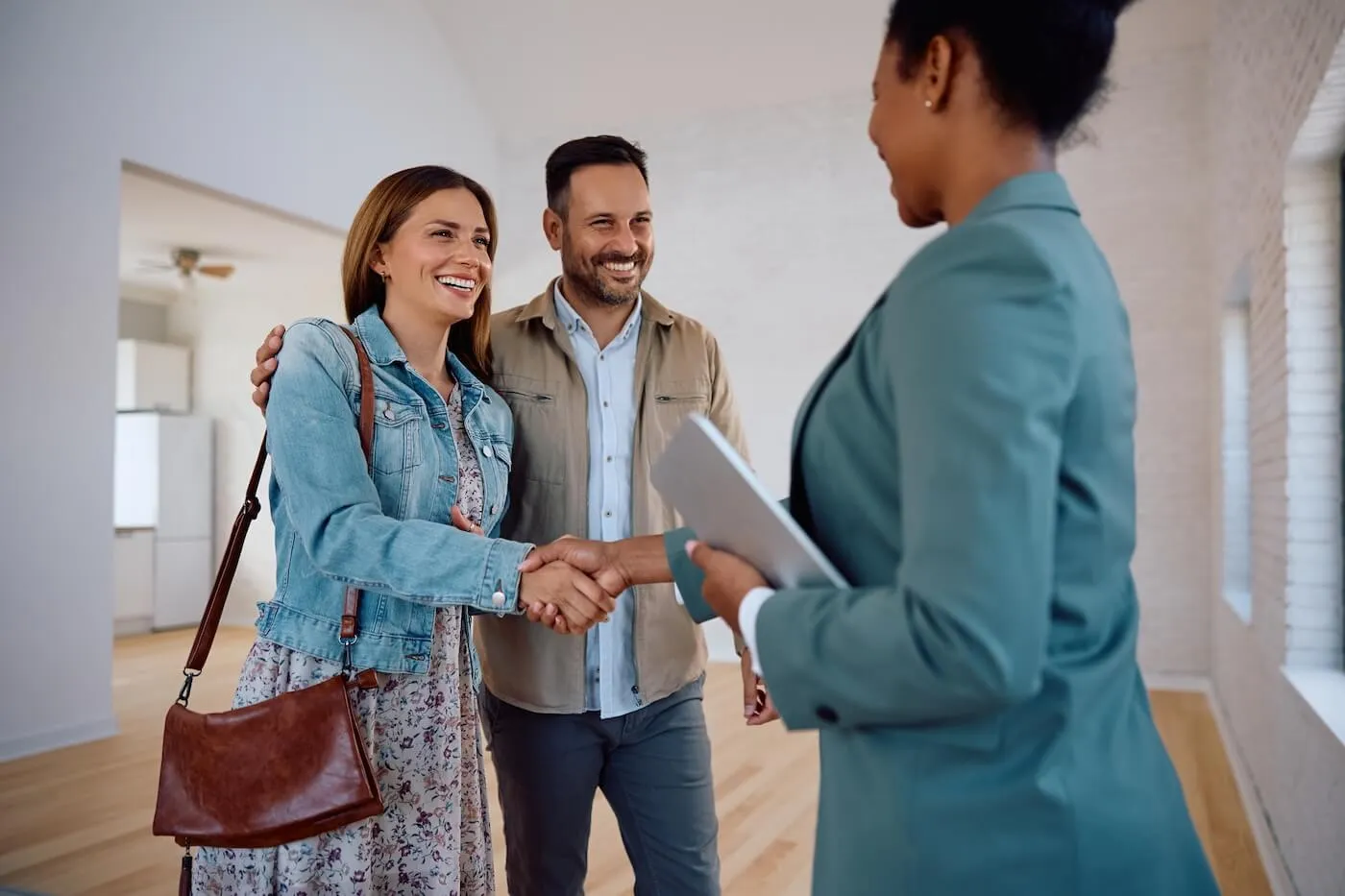 Happy couple shaking hands with a real estate agent