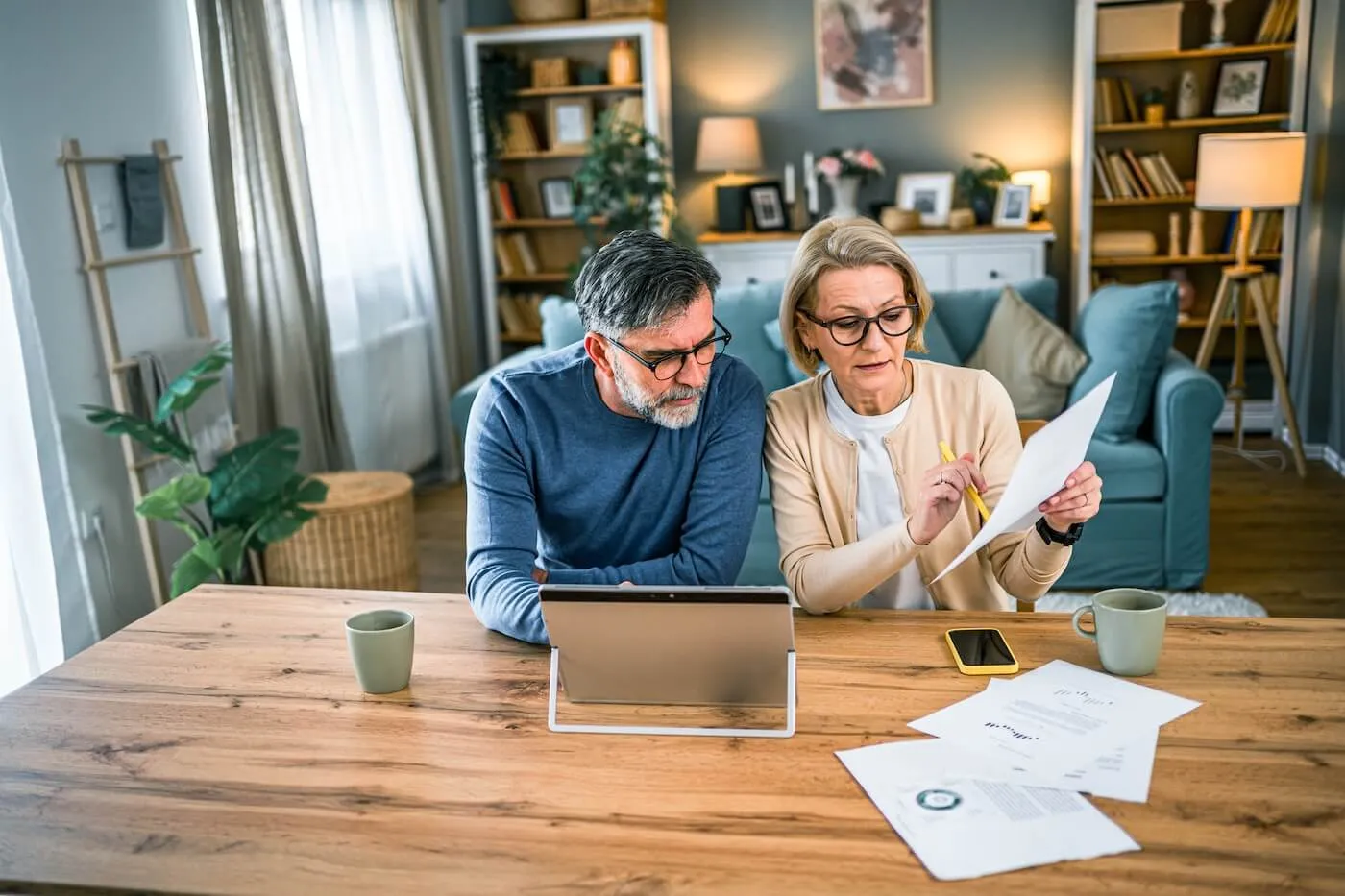 Focused senior couple filing taxes at home