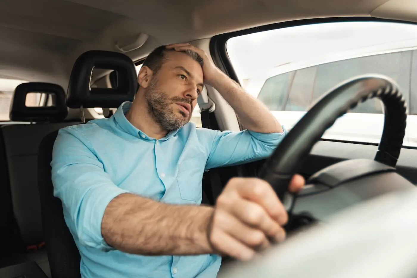 Tired mature man sitting in the car
