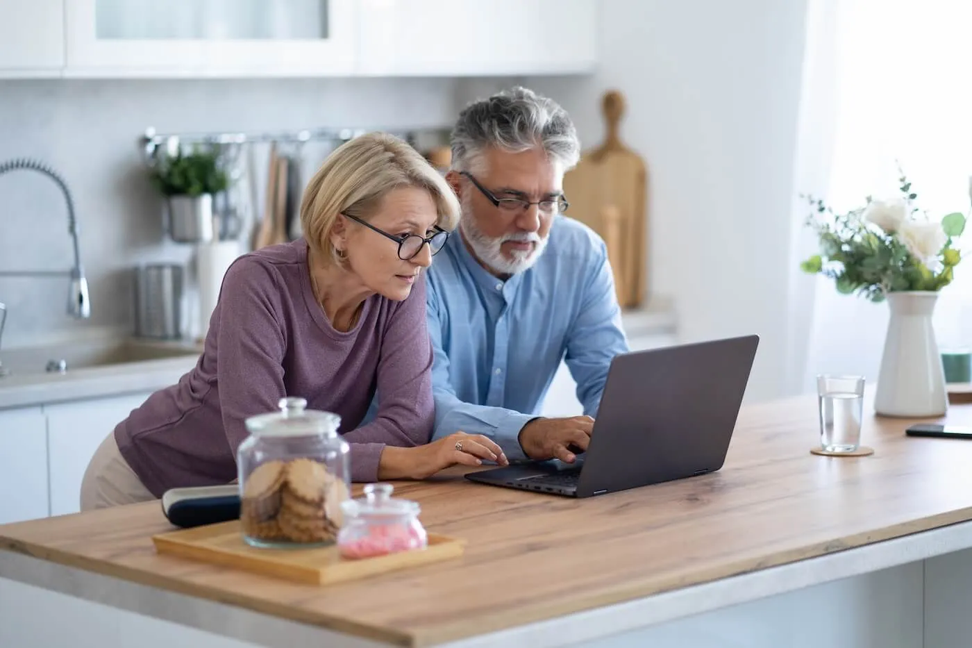 Mature couple using laptop in the kitchen