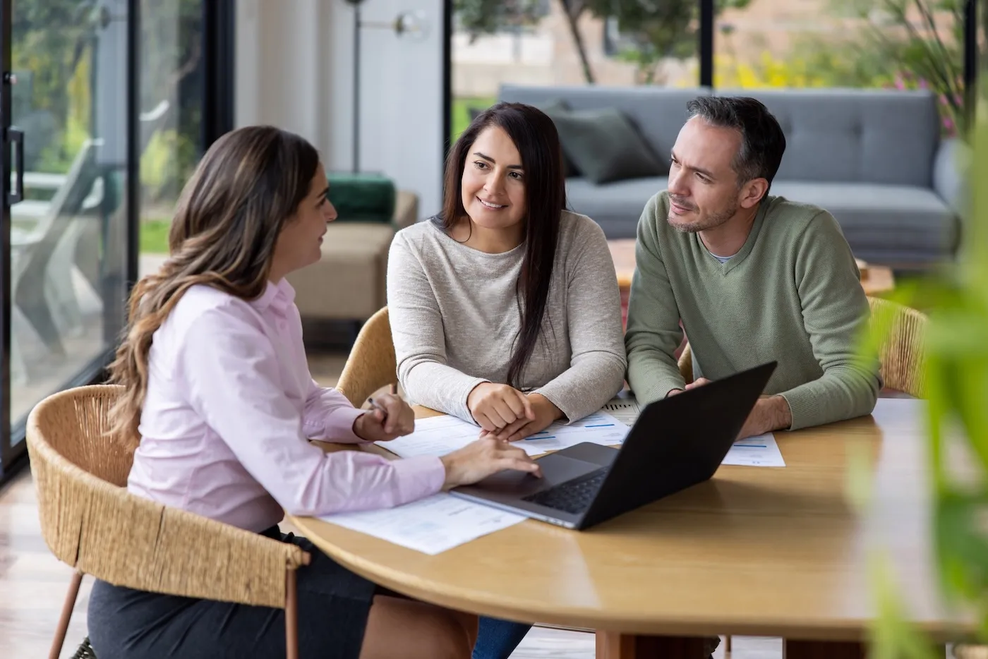 Female financial advisor talking to a couple at their house about their home refinancing