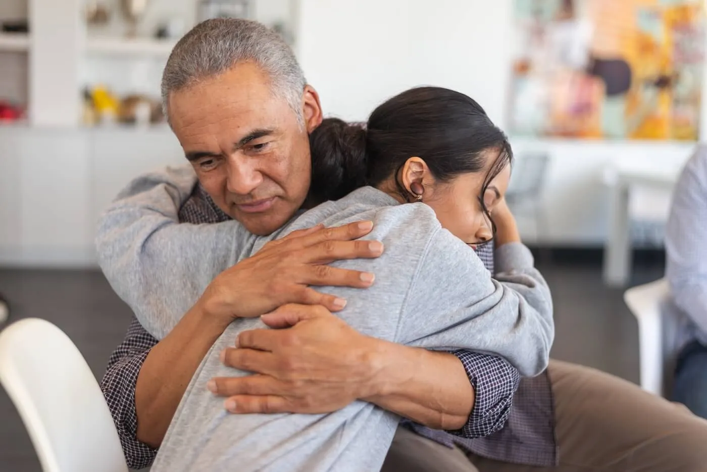 Caring father hugging his teenage daughter to comfort her.
