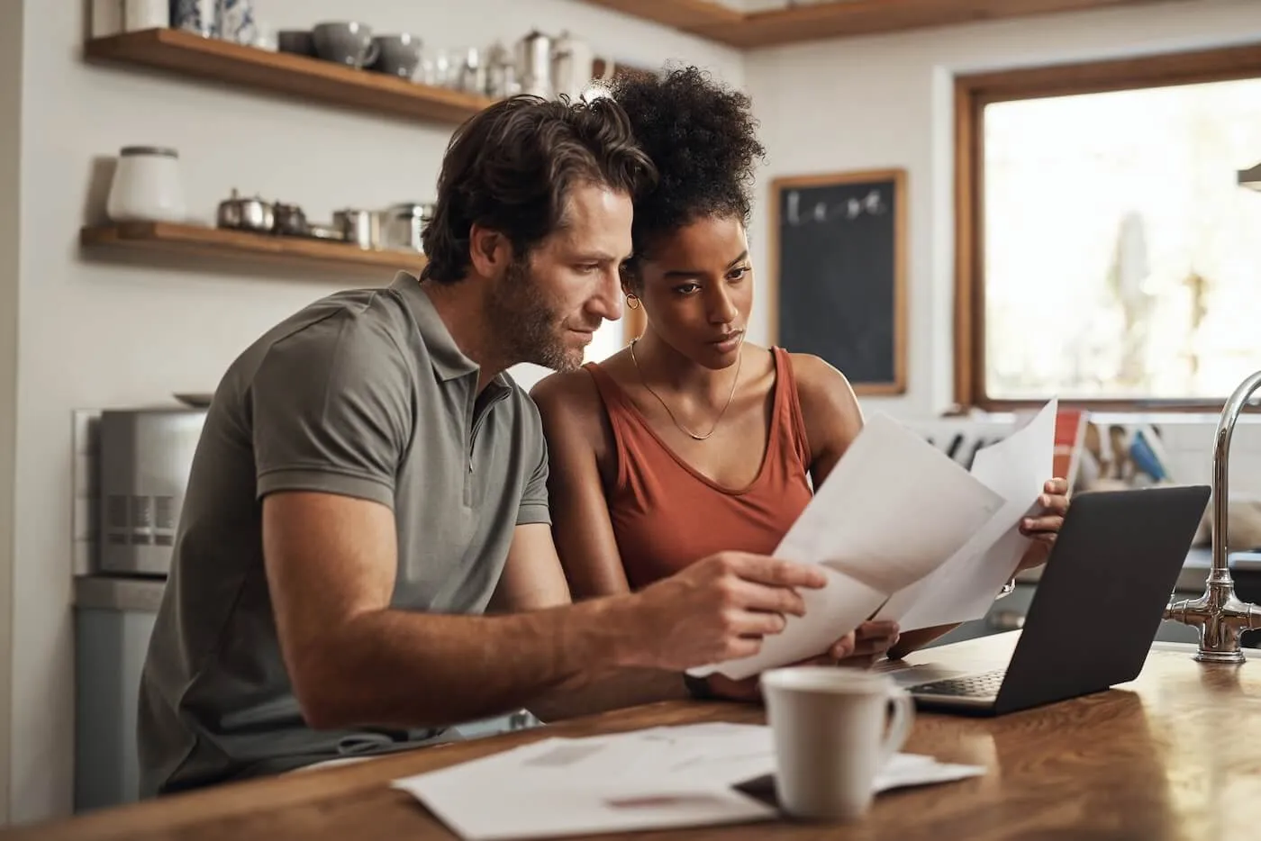 Focused couple reviewing the printouts in the kitchen