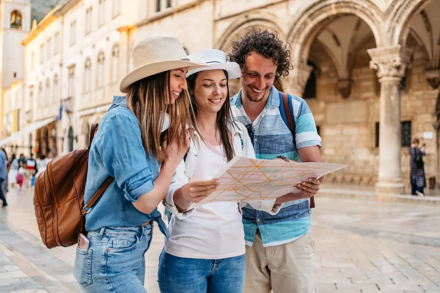 Group of friends in a European old town square, looking at a map together