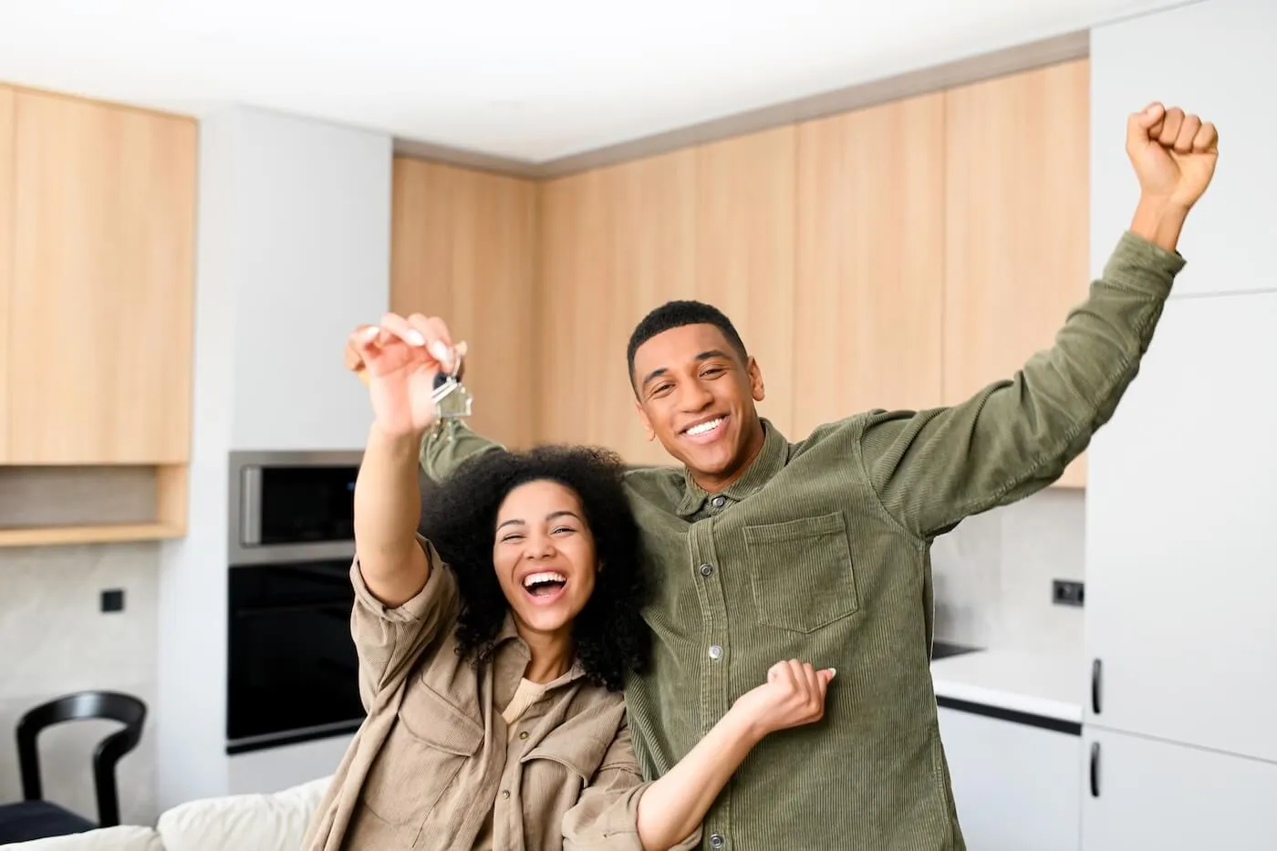 Photo of the excited young couple holding the keys from their new home