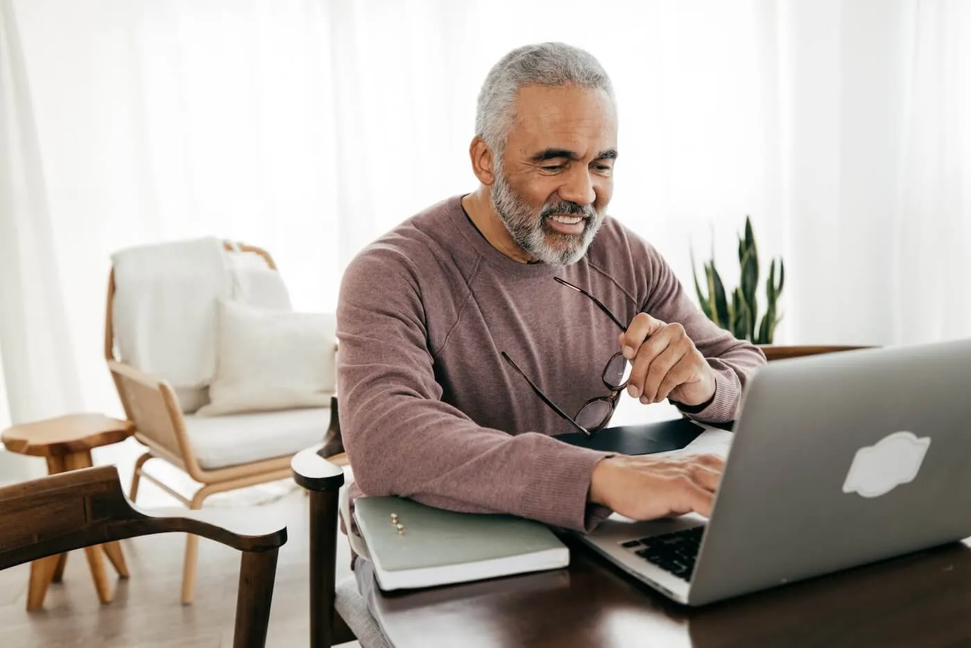 Smiling senior man using his laptop at home