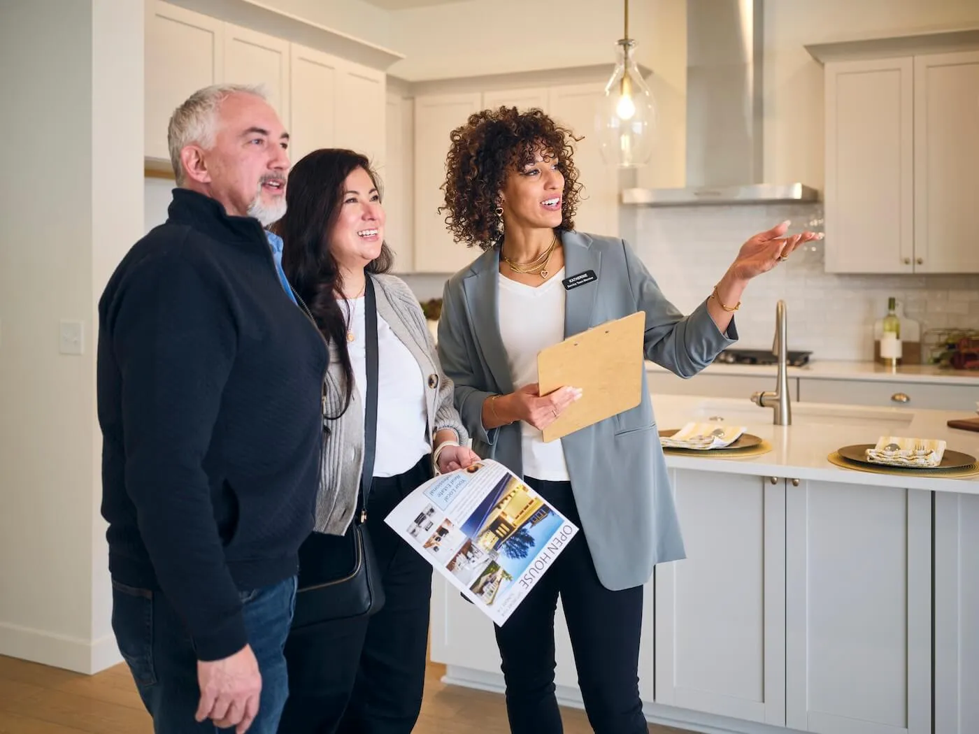 A female real estate agent shows a new home to a mature couple.