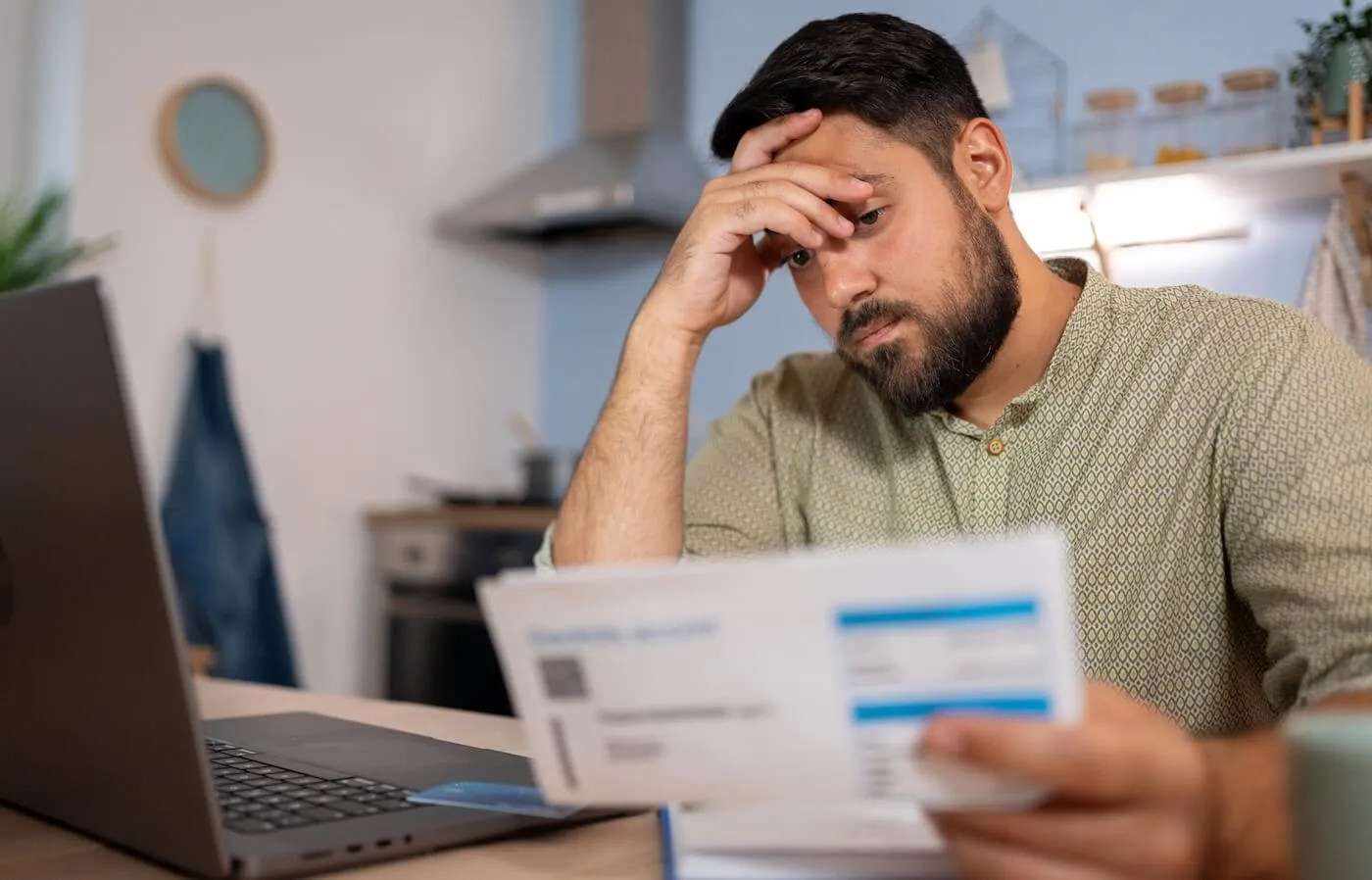 Concerned man paying the bills on his laptop