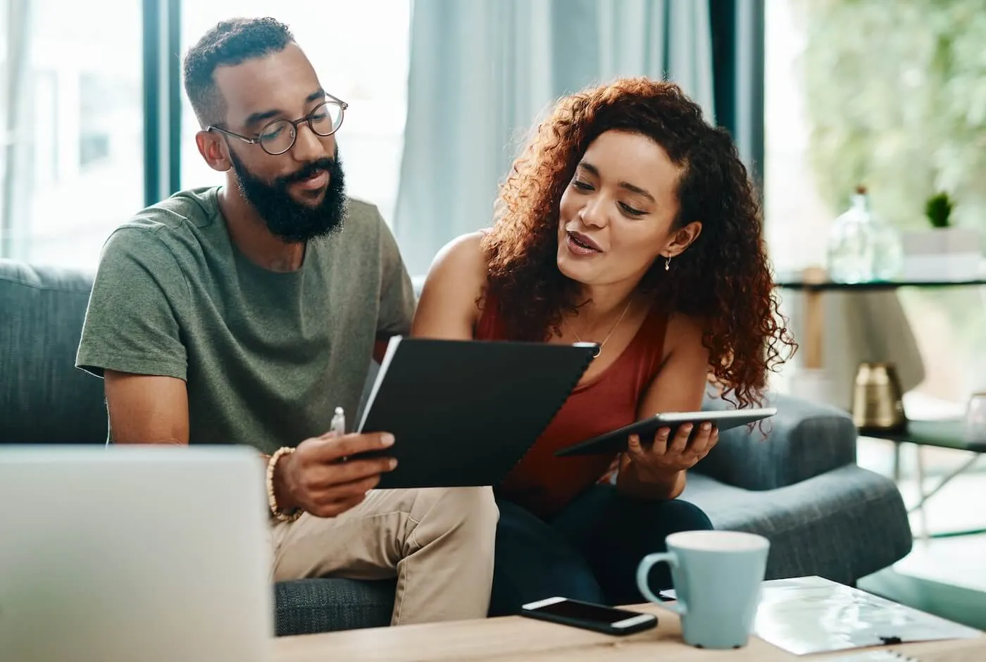 Happy couple calculating their expenses at home