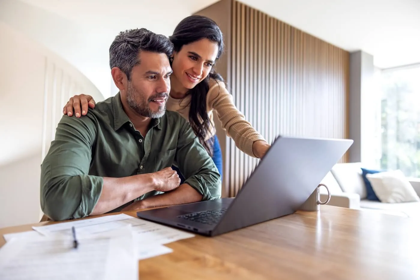 Mature couple using laptop at home to calculate their home equity