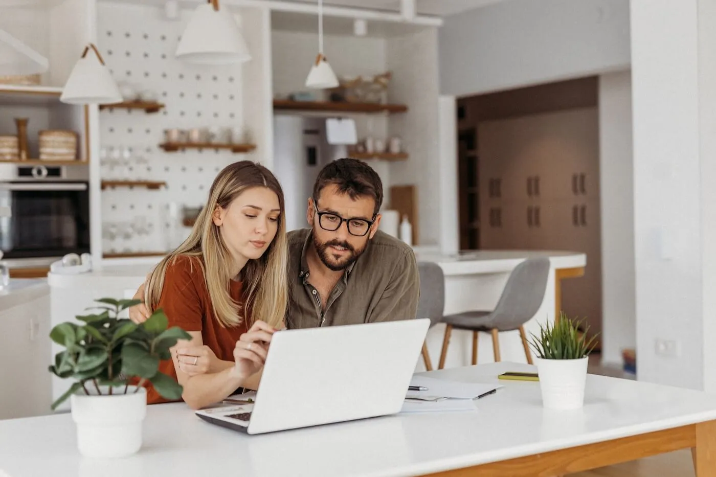 Focused young couple choosing a mortgage lender online at home