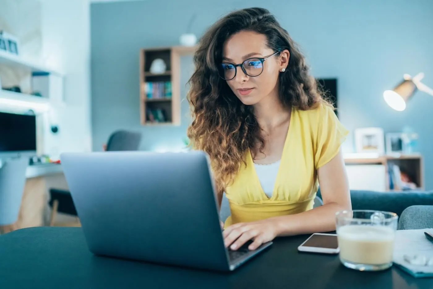 Young woman in glasses making wire transfer online at home