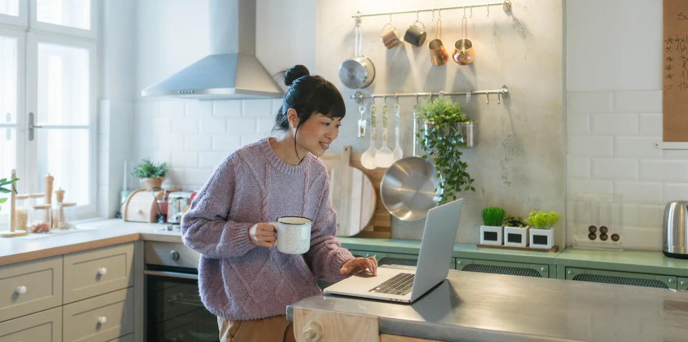 Photo of a woman using a laptop while working from her home.