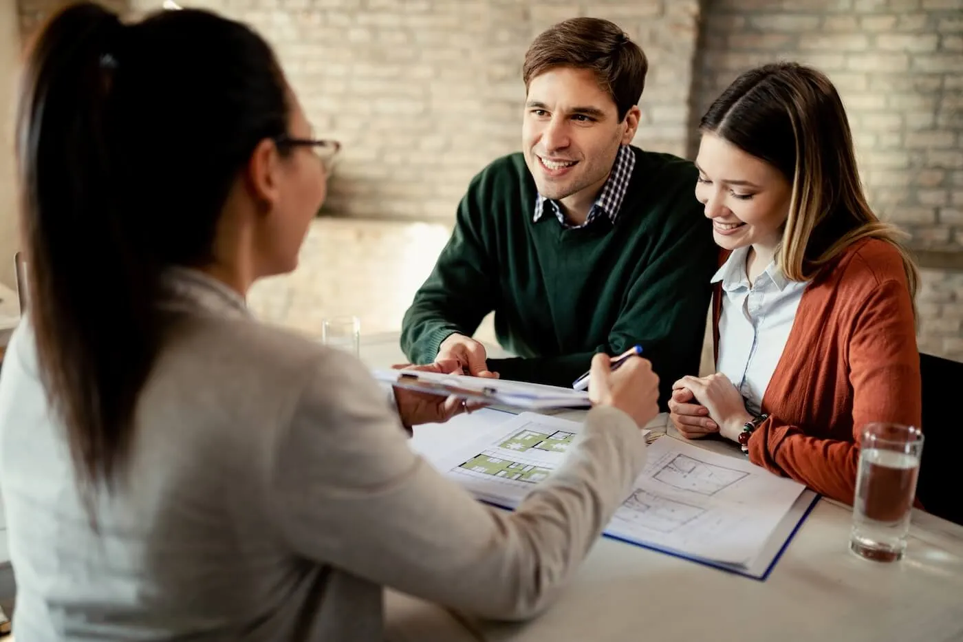 Young couple discussing their mortgage options with a female real estate agent