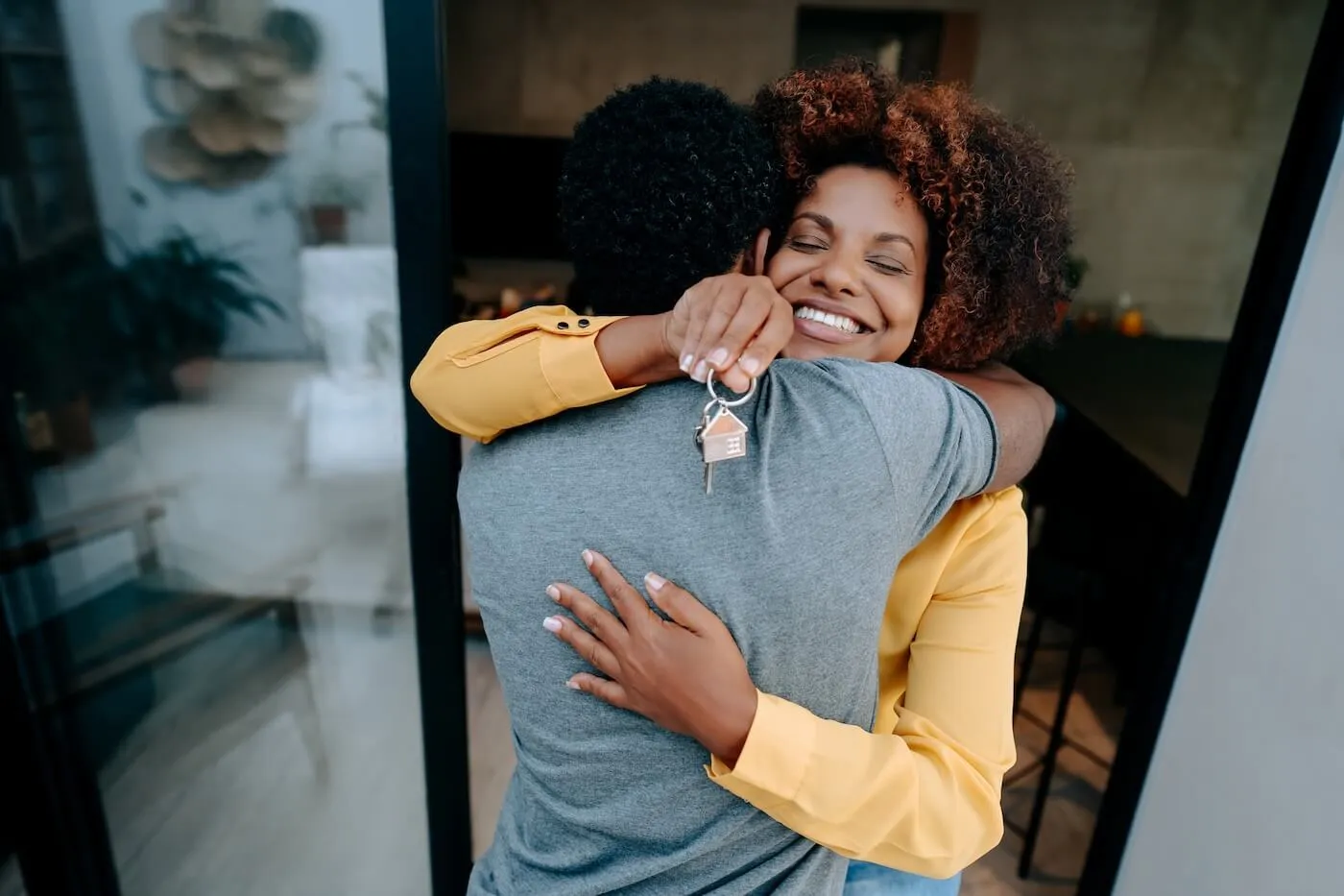 Happy woman hugging her partner and holding the house keys