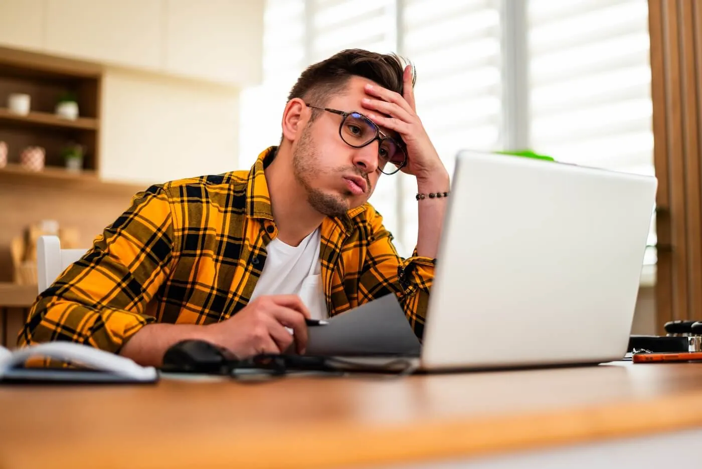 Concerned man using his laptop at home