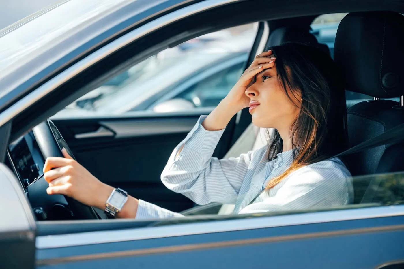Frustrated young woman driving a car