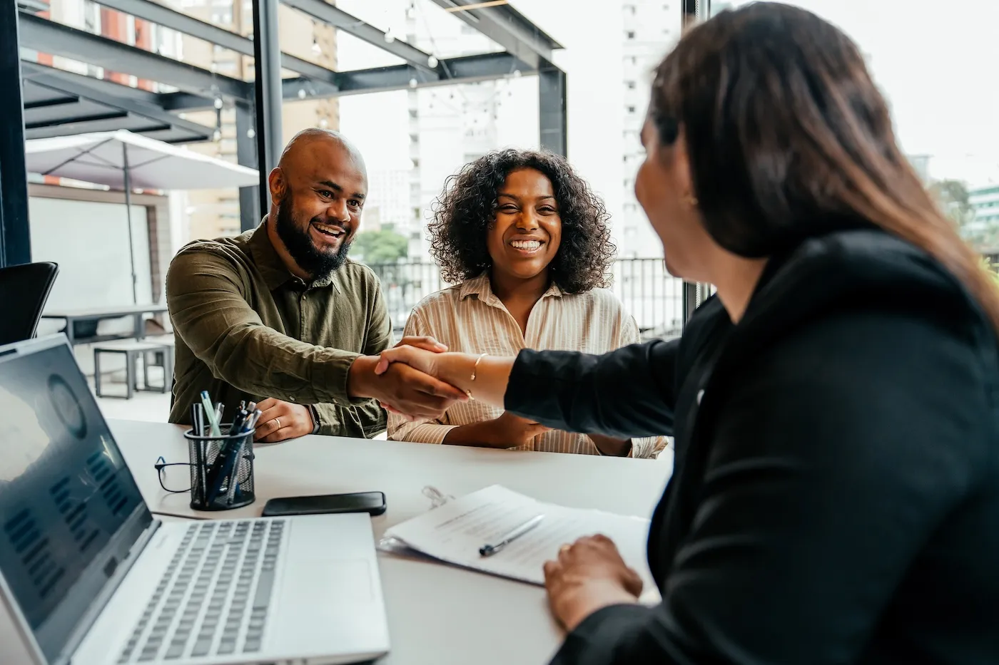 Couple closing contract with loan officer.