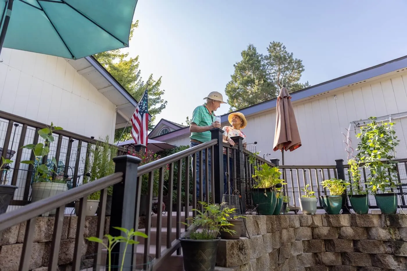 Happy senior couple relaxing on the deck of their manufactured home, enjoying a sunny day together