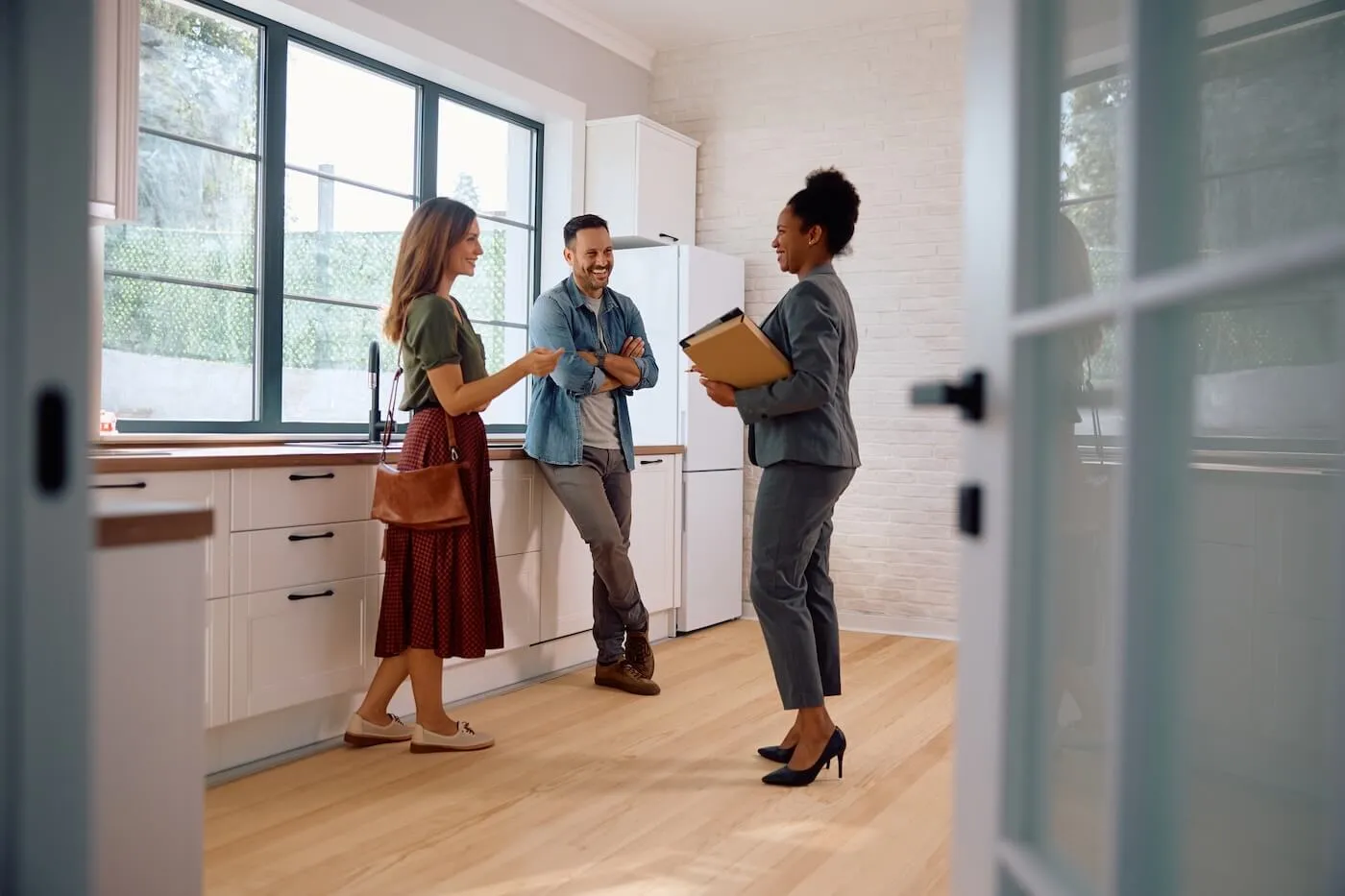 Young couple having a chat with a female agent during the open house
