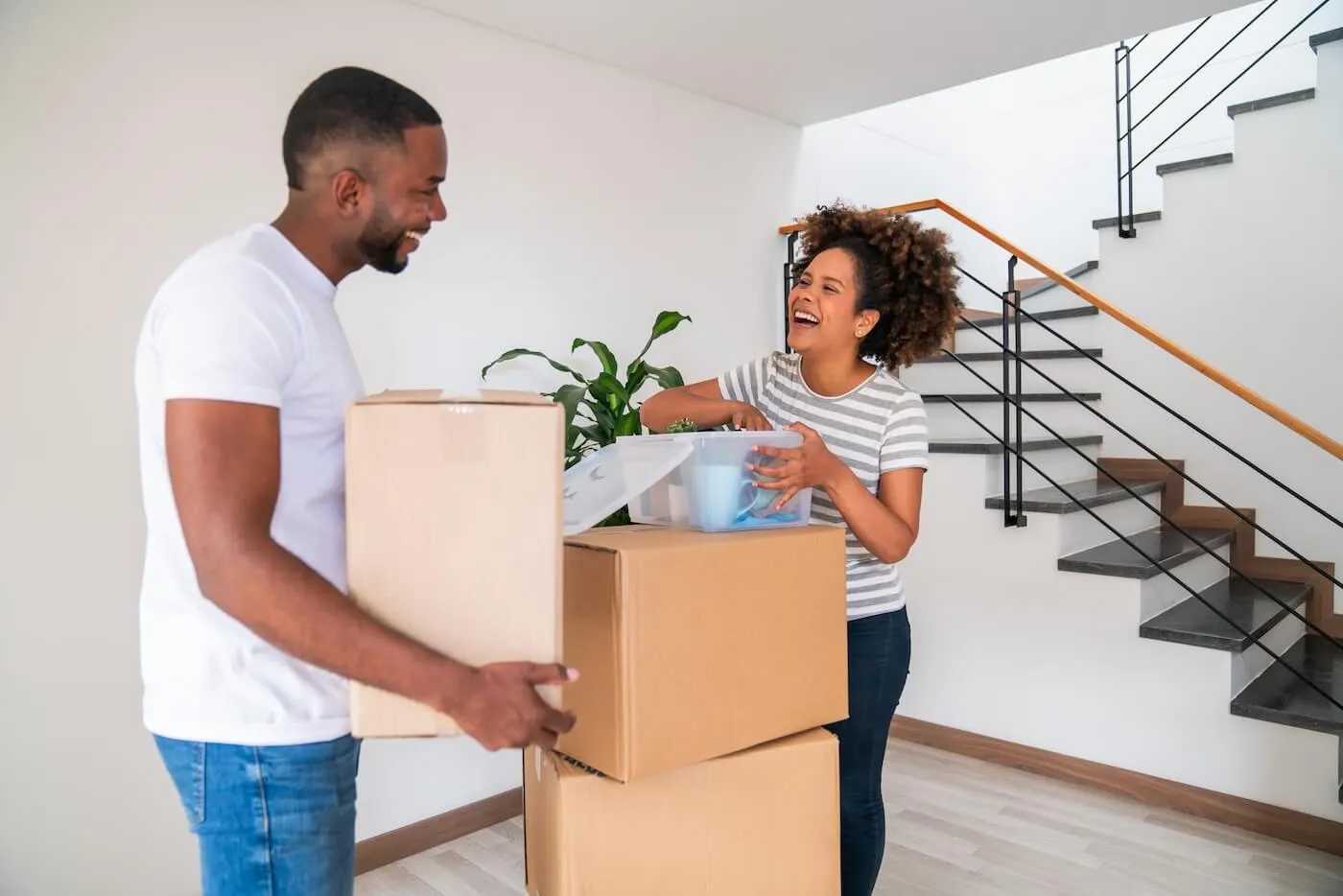 Happy young couple unpacking the boxes in their new home
