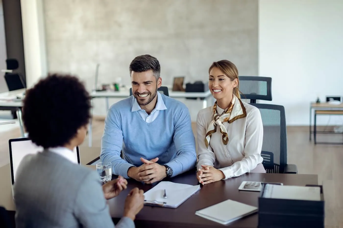 Couple discussing mortgage terms with the female lender in her office