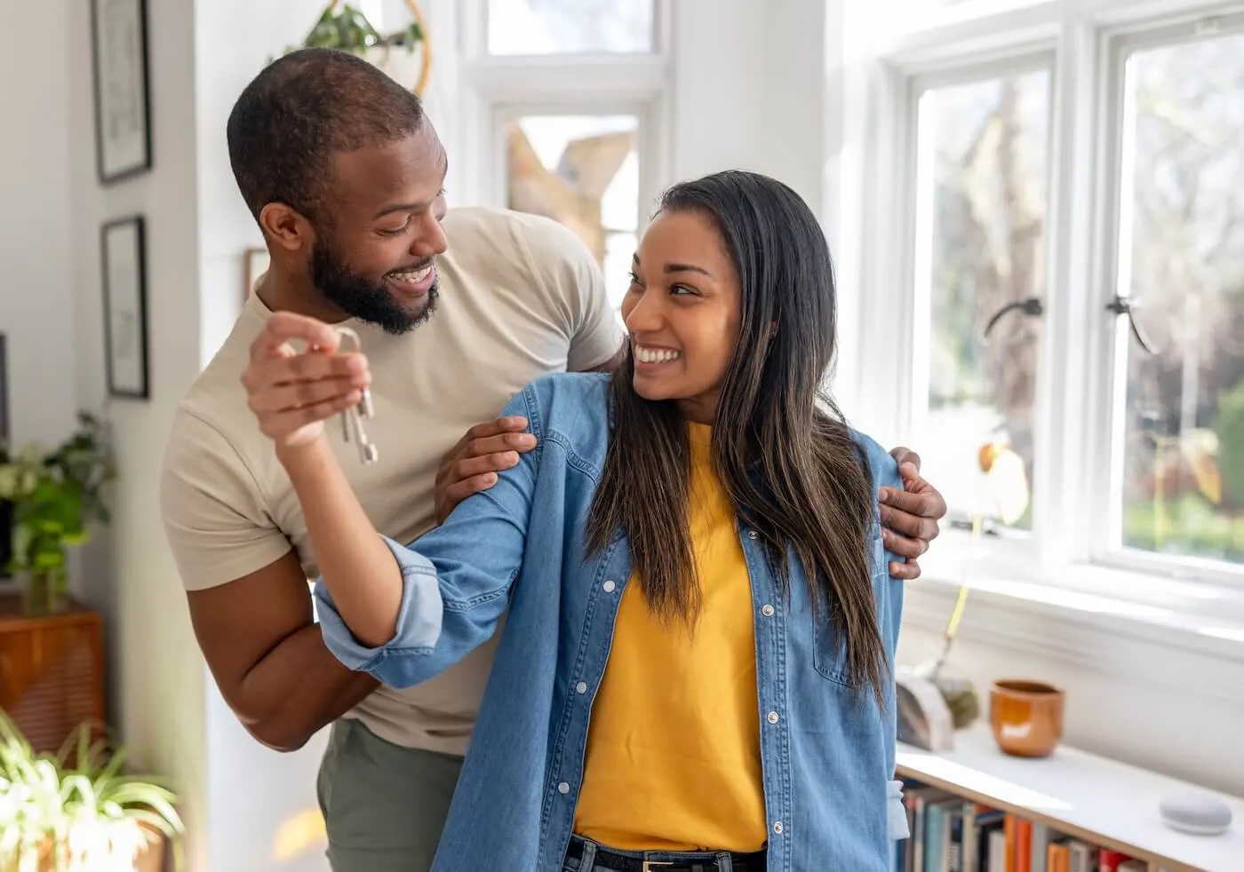 Happy young couple holding keys from their new home