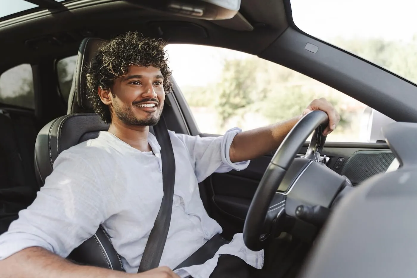 Smiling young man driving a car