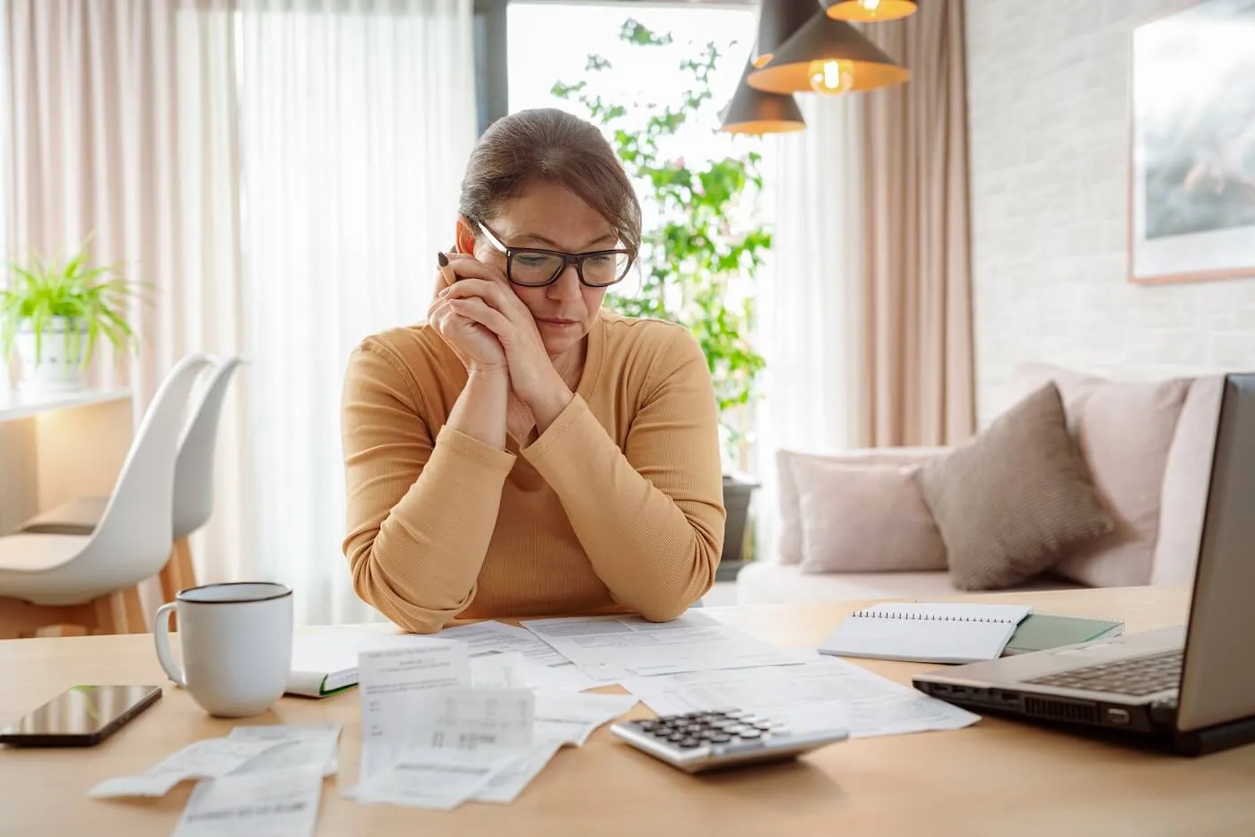 Focused mature woman filing taxes online at home