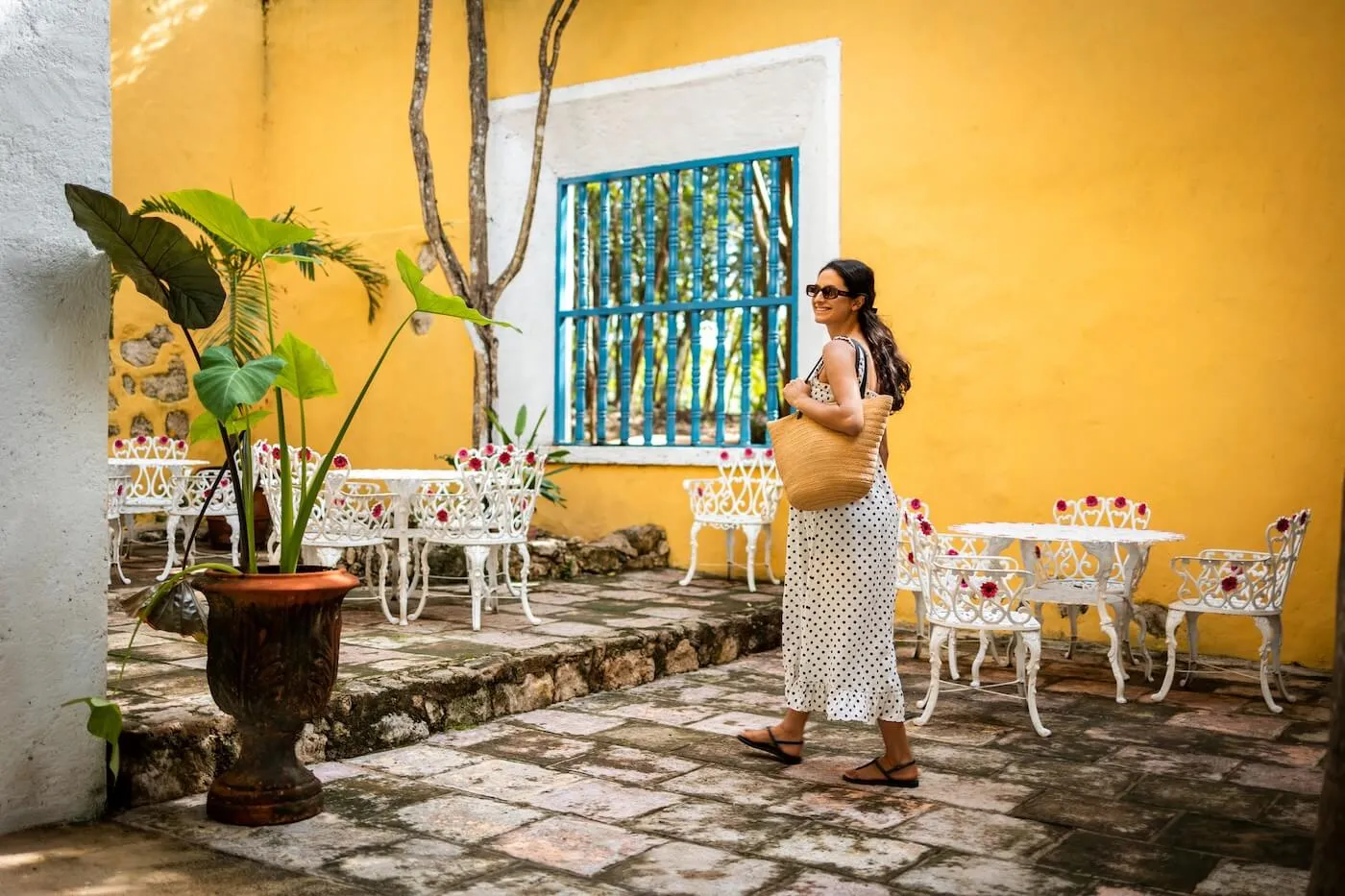 Smiling woman enjoying her vacation in an old Mexican town, surrounded by colorful architecture