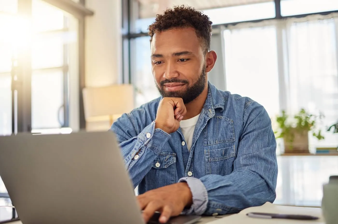 Pensive young man using his laptop
