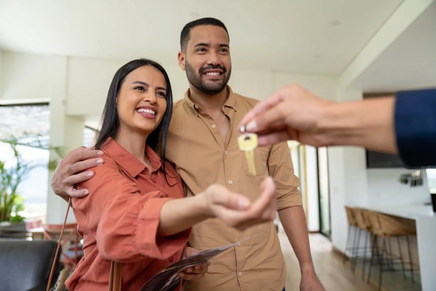Happy couple taking the new house keys from the real estate agent.