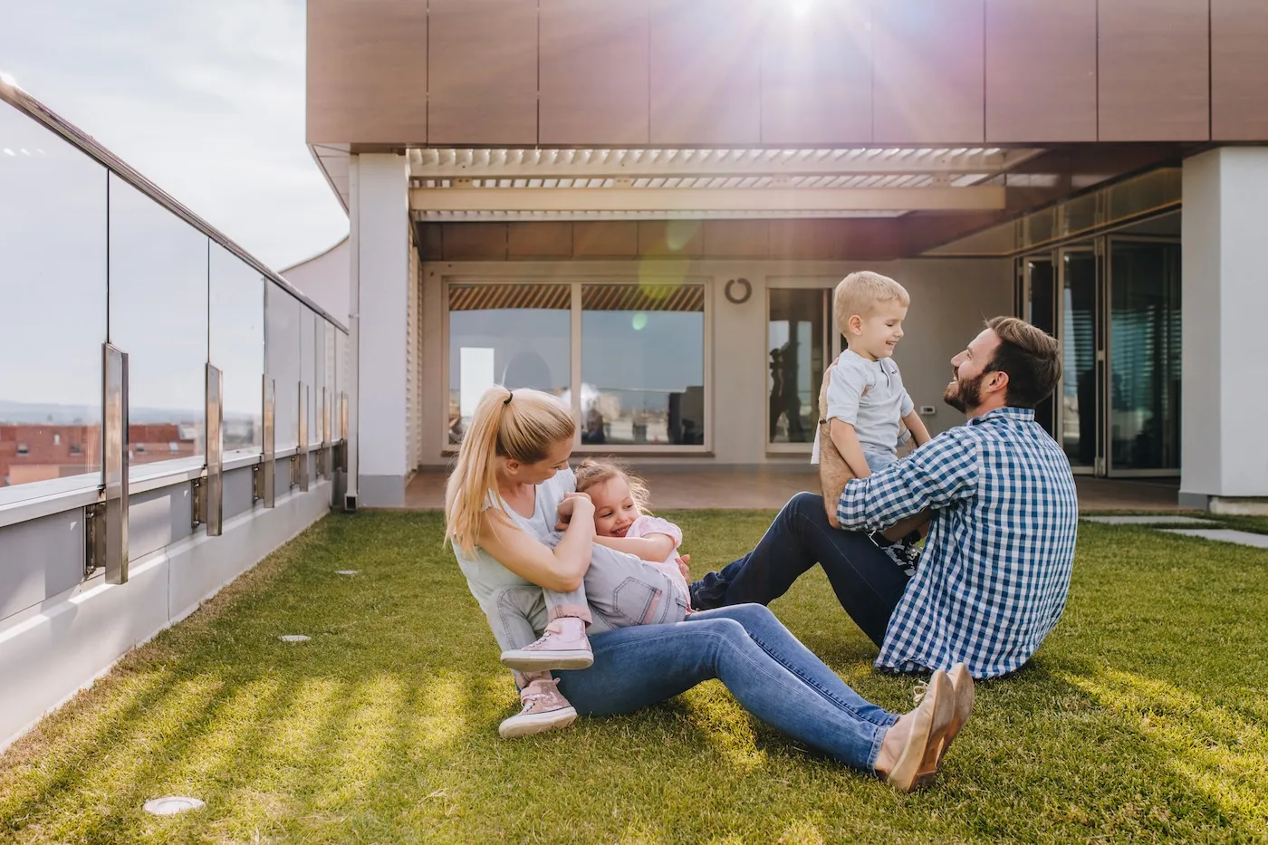 Happy family with two young kids having fun on a rooftop terrace