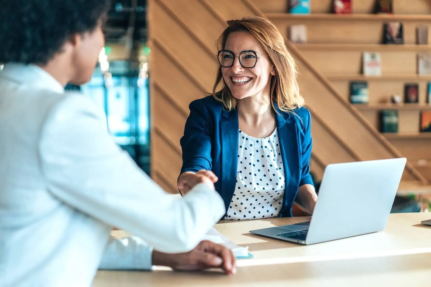 Two business women shaking hands in the office