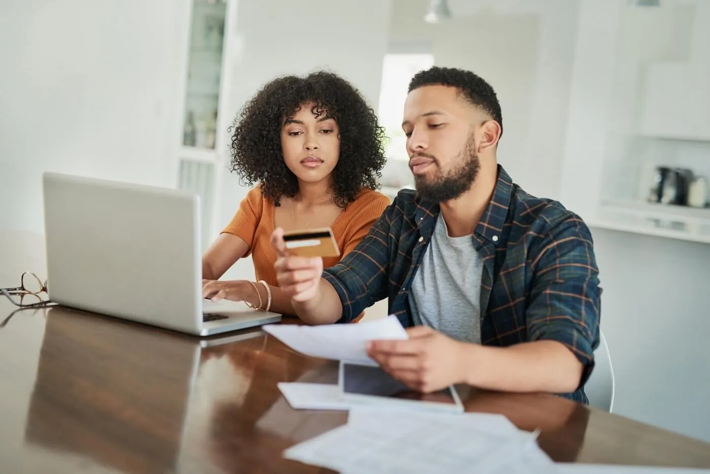 Focused couple using credit card online to pay bills
