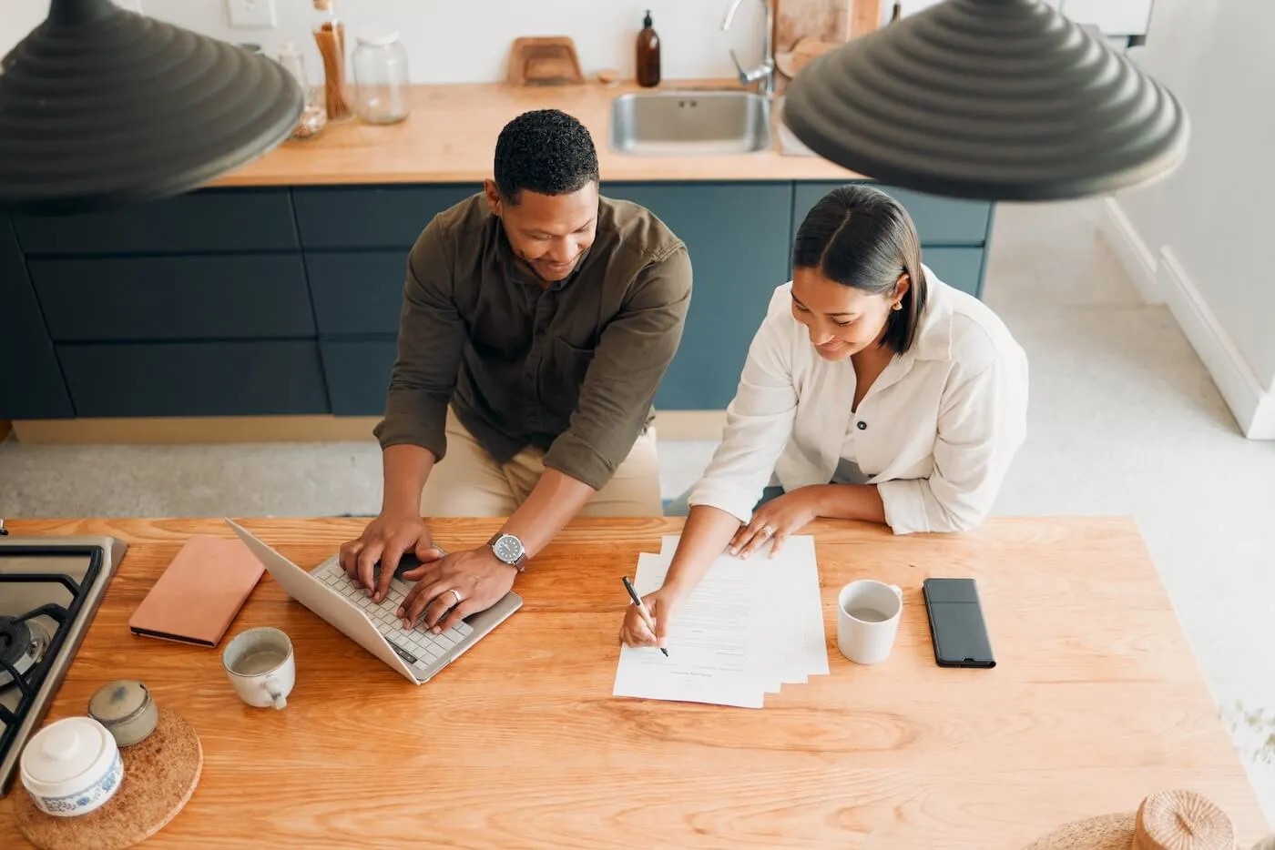 Young couple planning their finances and using the laptop in the kitchen, the photo is taken from above