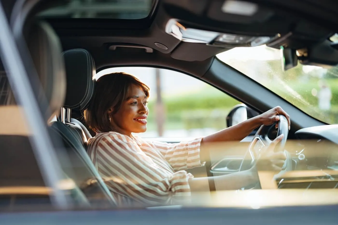 Smiling confident woman driving a car
