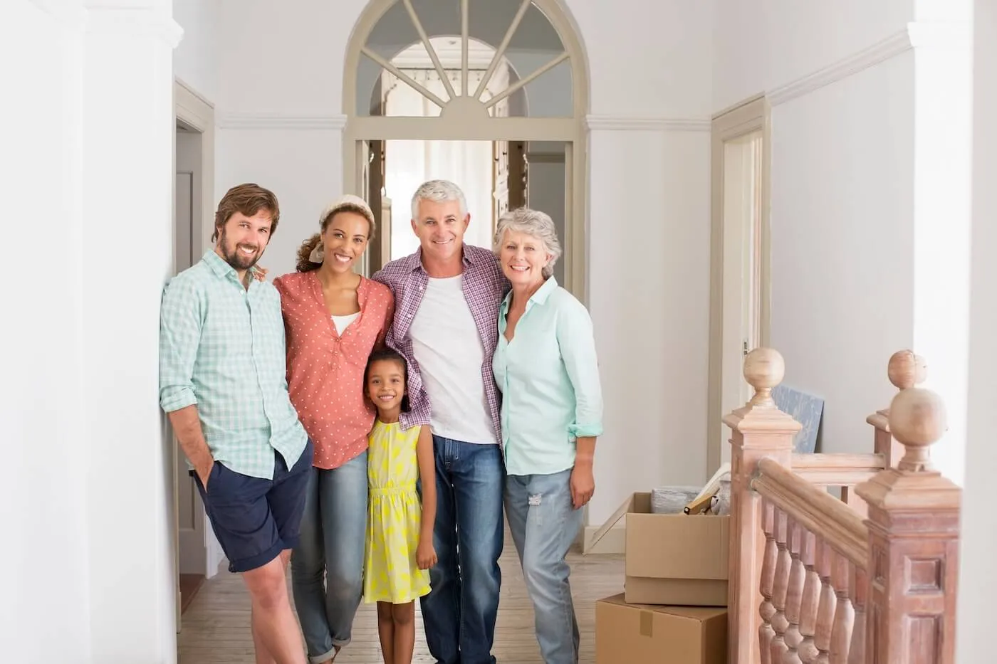 Photo of a family standing in the new home: senior and young couples and a young girl