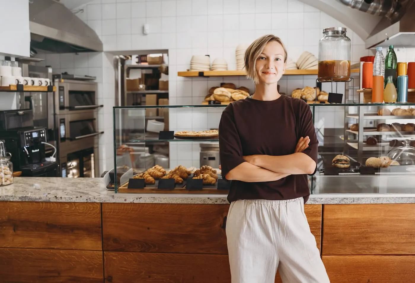 A photo of a young confident woman standing in a bakery