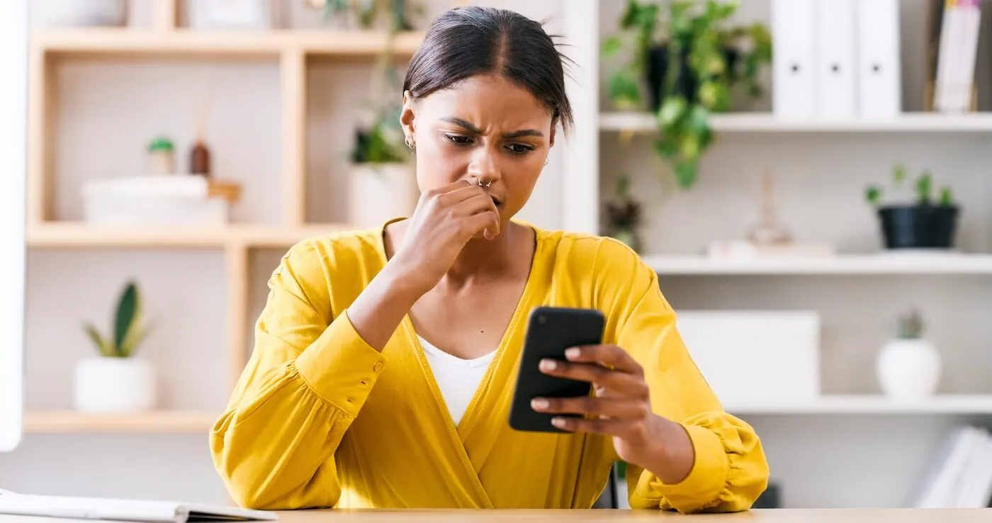 Concerned young woman looking at her smartphone