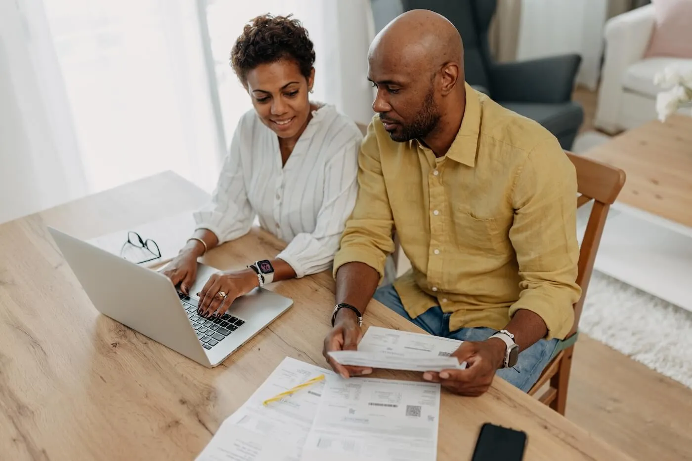 Focused couple working on budget plans with laptop open