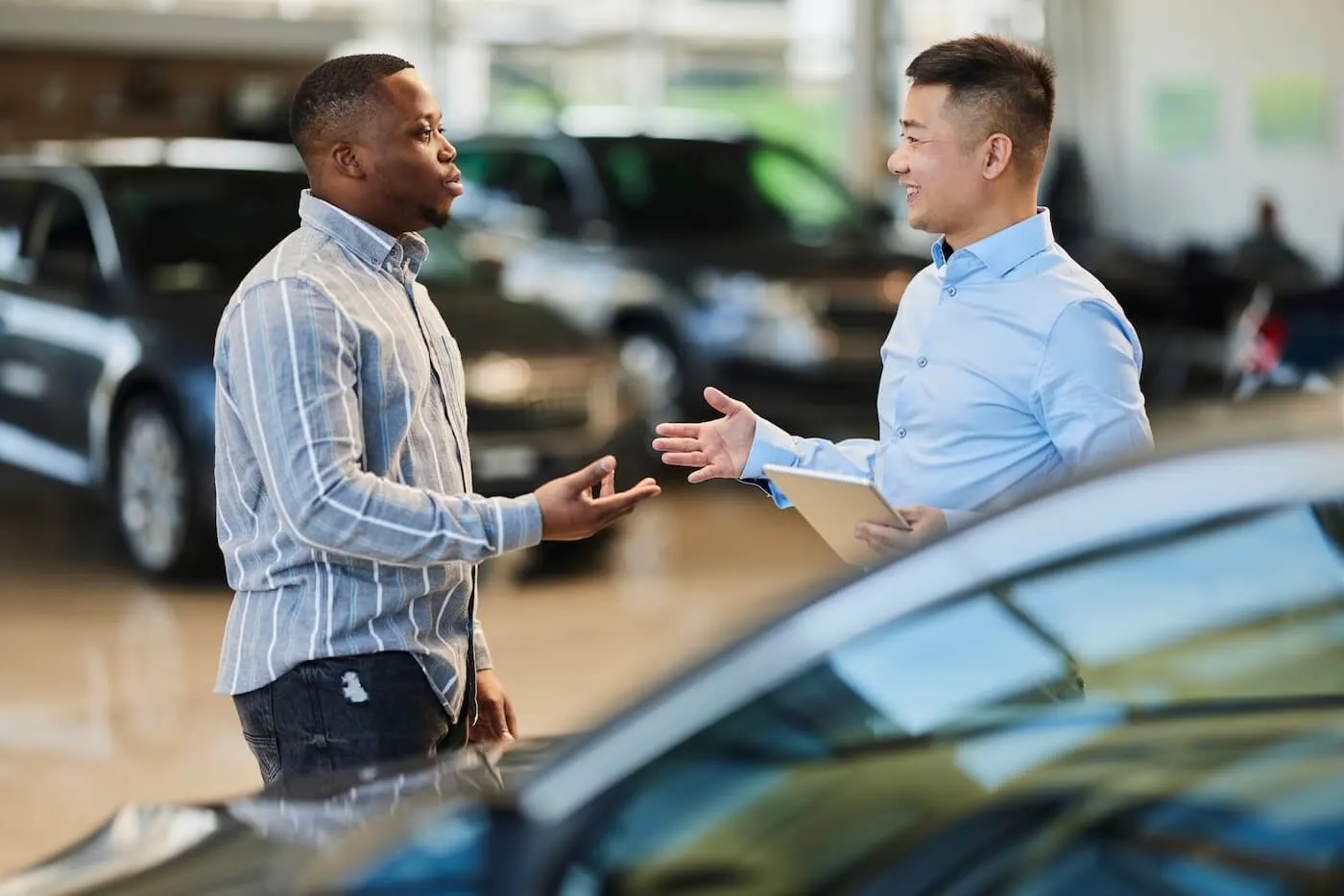 Sales agent talking to a male customer in the car dealership