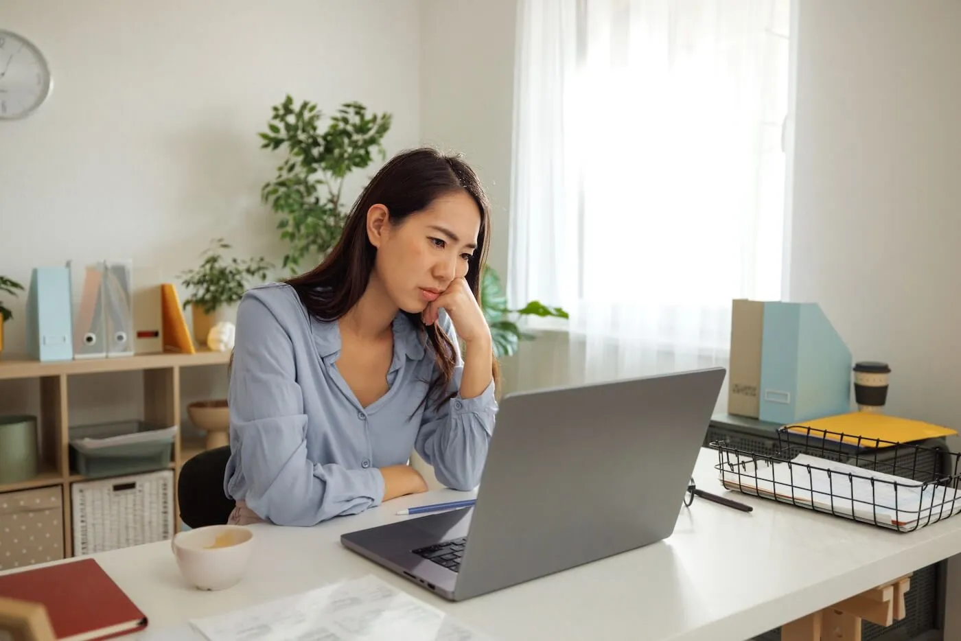 Concerned woman looking at a laptop screen while sitting in an office