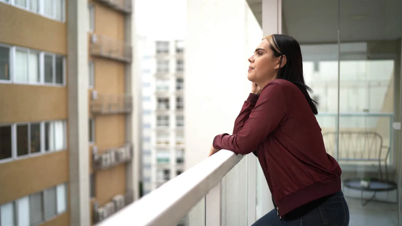 Woman standing on balcony of new rental property.