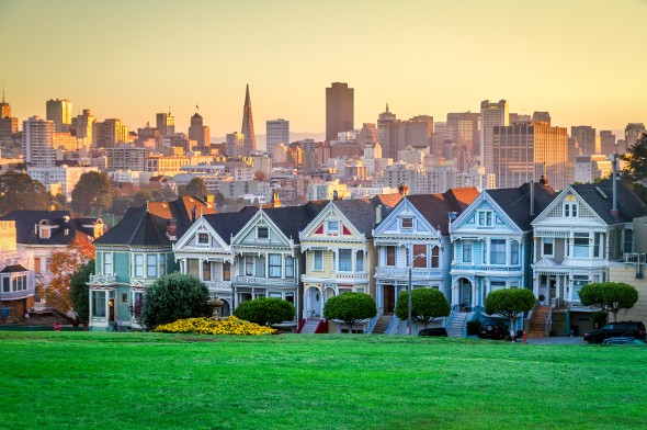 A row of houses against a city skyline.